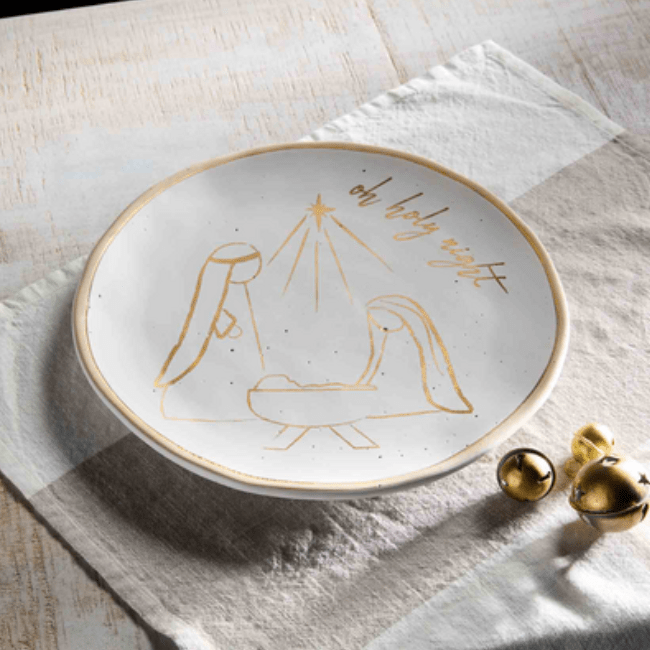 Gold Nativity Platter featuring a hand-painted nativity scene and "Oh holy night" in gold on a 12" speckled stoneware platter styled on a table.