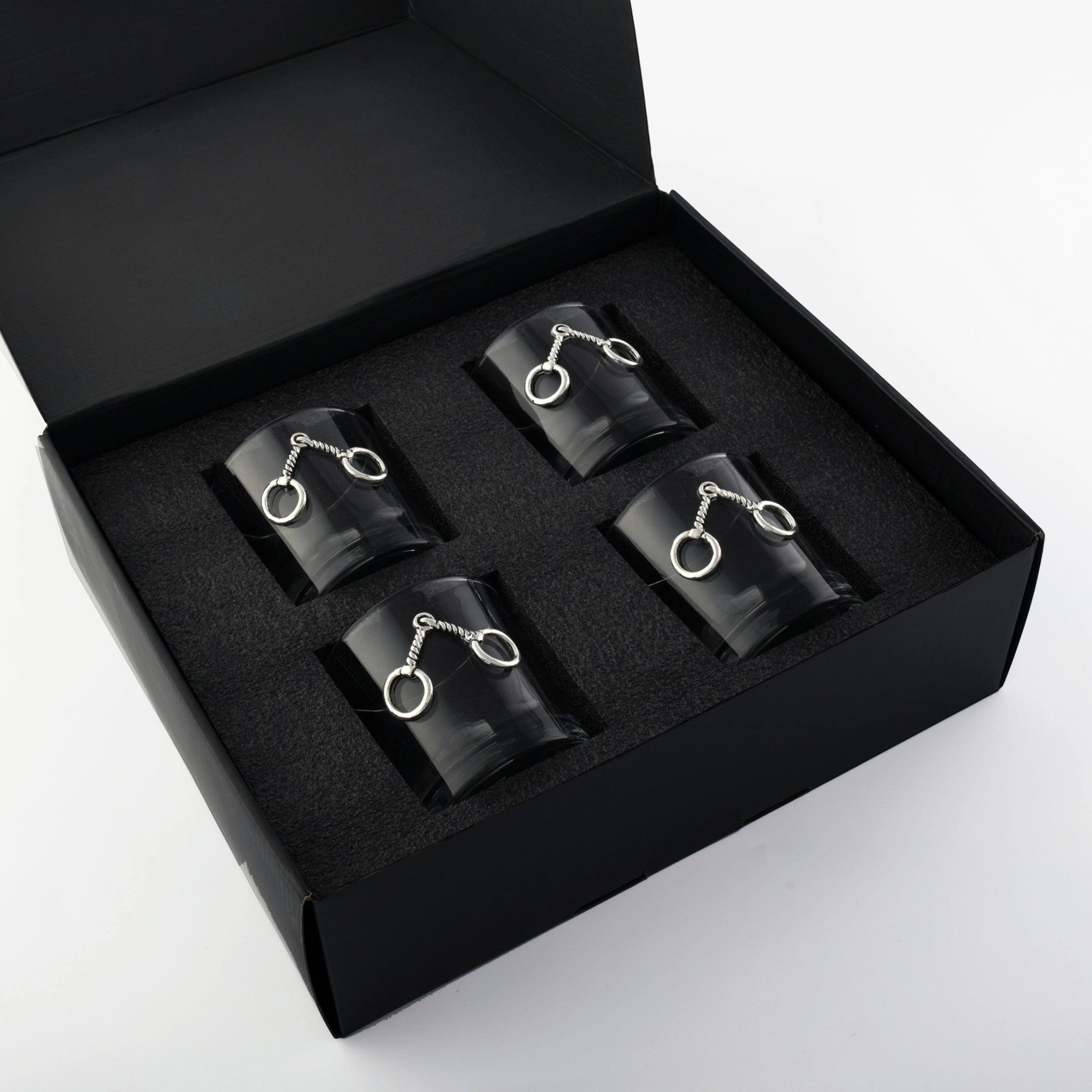 The set of four equestrian bit bar glasses displayed in their stylish black presentation gift box.
