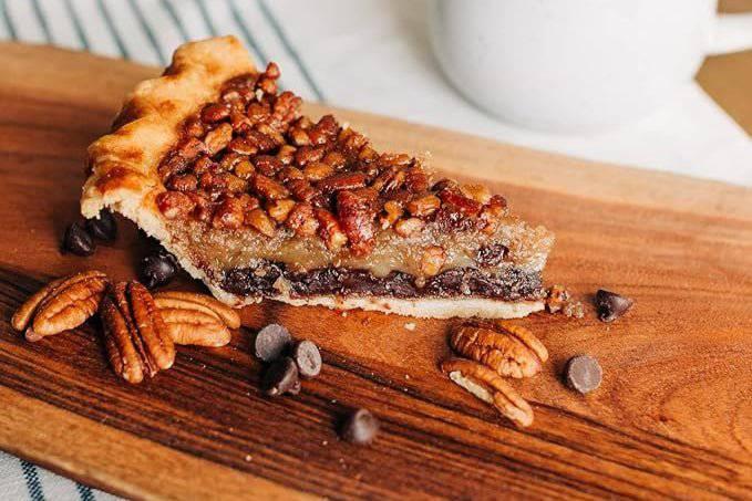 A warm lifestyle shot of a slice of Bourbon Chocolate Chip Pecan Pie.