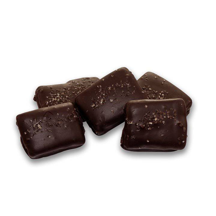 Close-up of the dark chocolate surface sprinkled with coarse bourbon smoked sea salt.