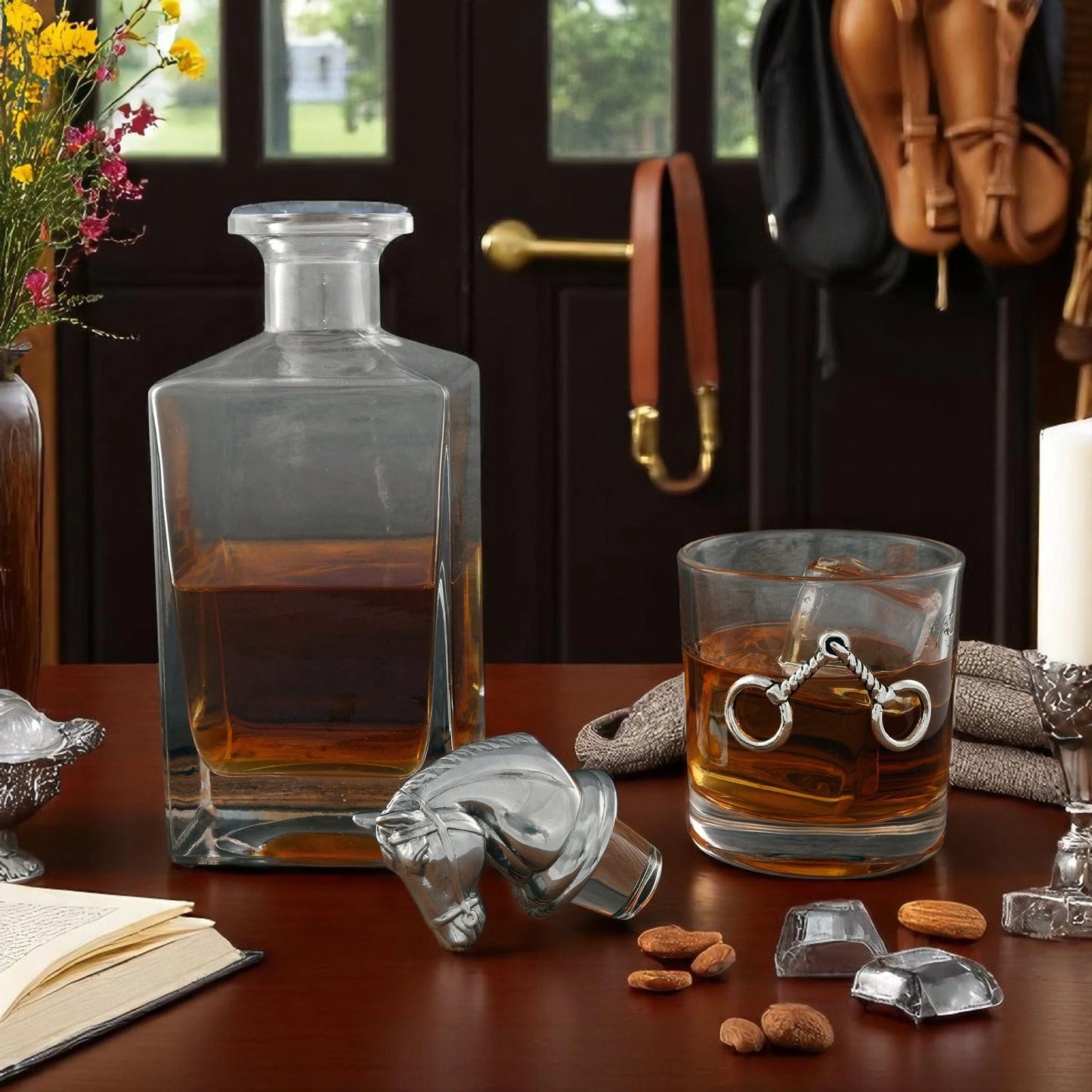 Glass decanter and glass with liquid on a table with decorative items.