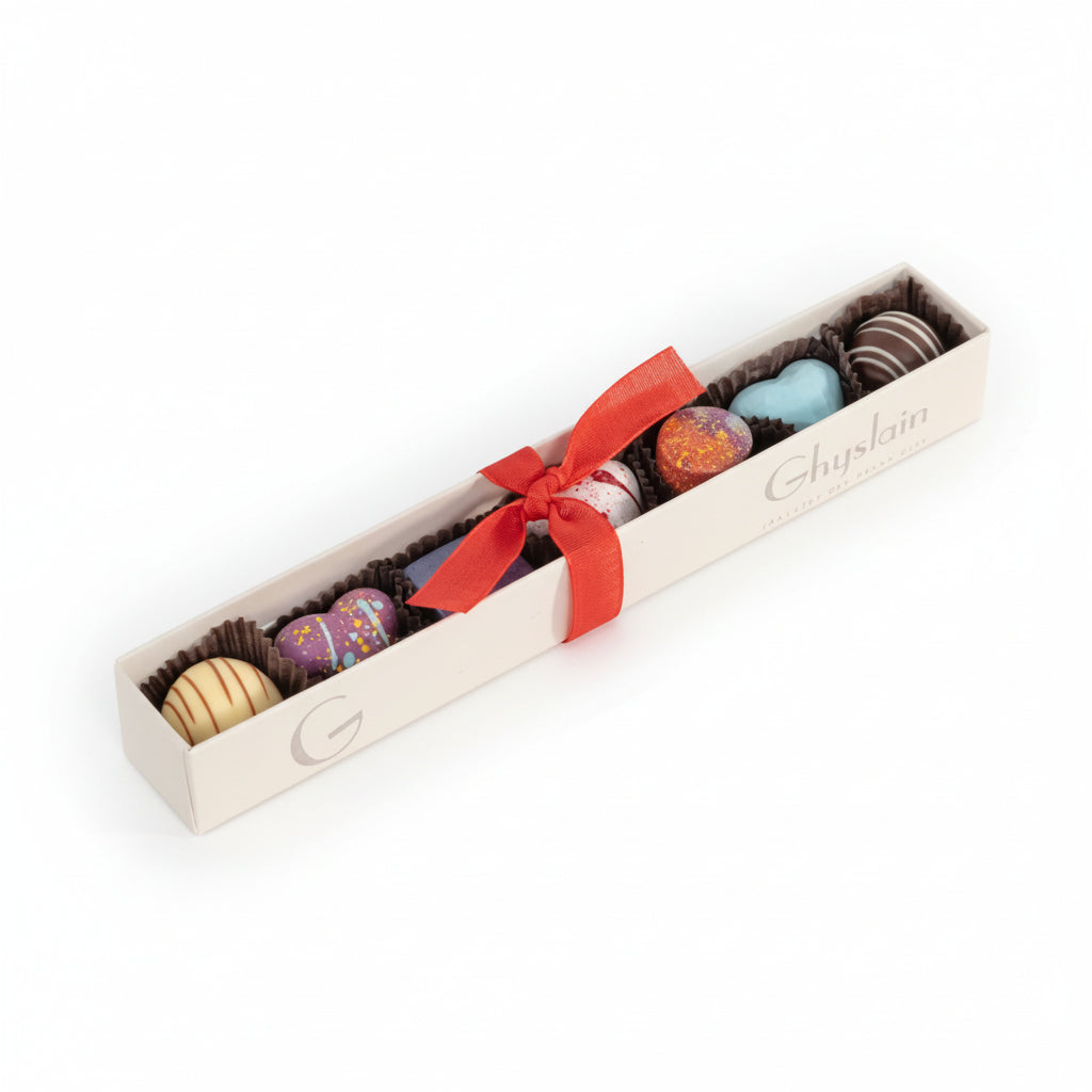 The Ghyslain Valentine Sleeve box featuring a window view of seven colorful, hand-painted chocolates.