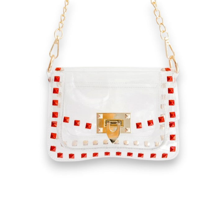 A front view of The Jackie clear stadium bag featuring bold red trim and polished gold hardware.