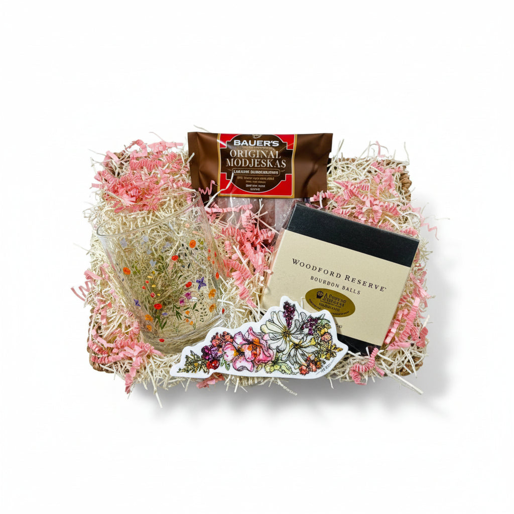 The Kentucky Wildflowers for Her Gift Basket featuring a floral rocks glass, sticker, and Woodford Reserve chocolates.