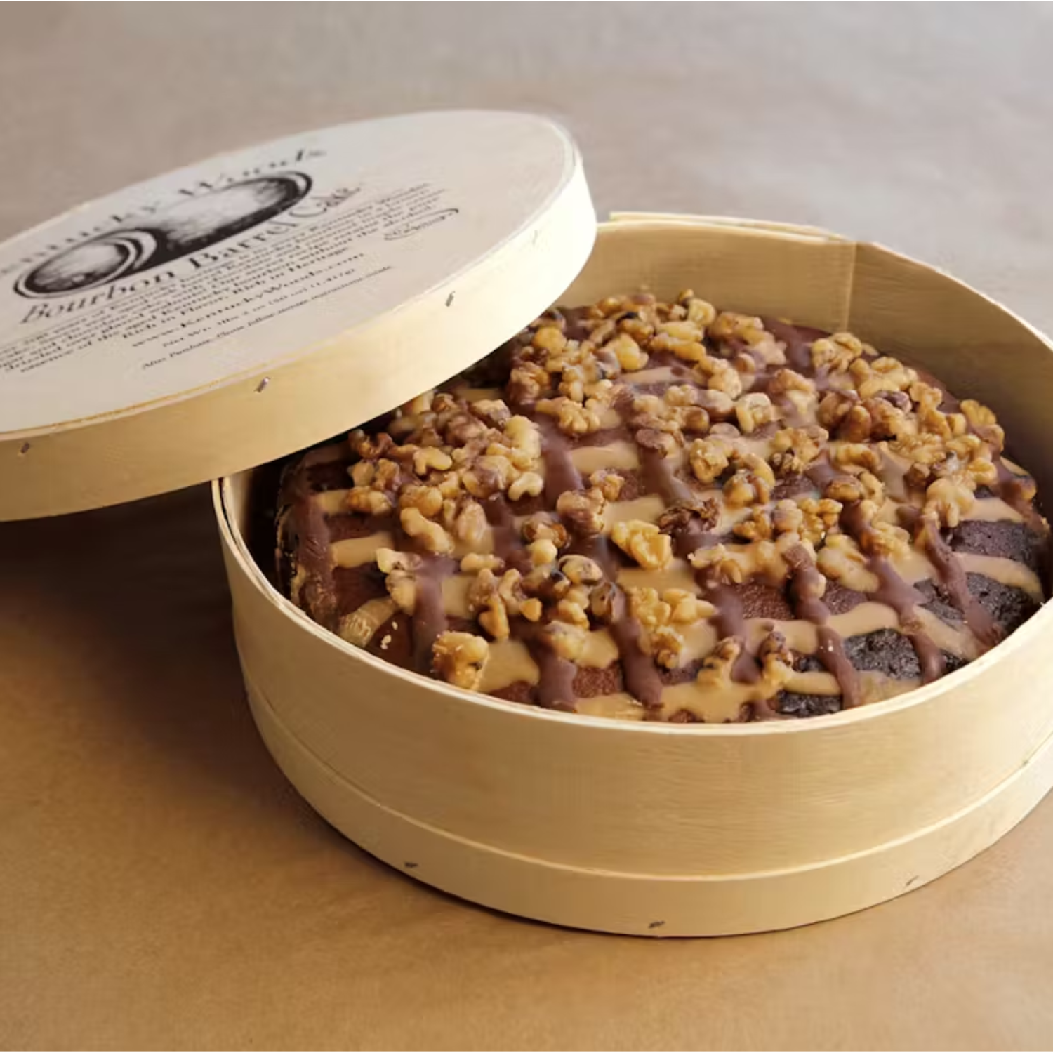 Round cake with walnut crumble in a cardboard box on a beige background