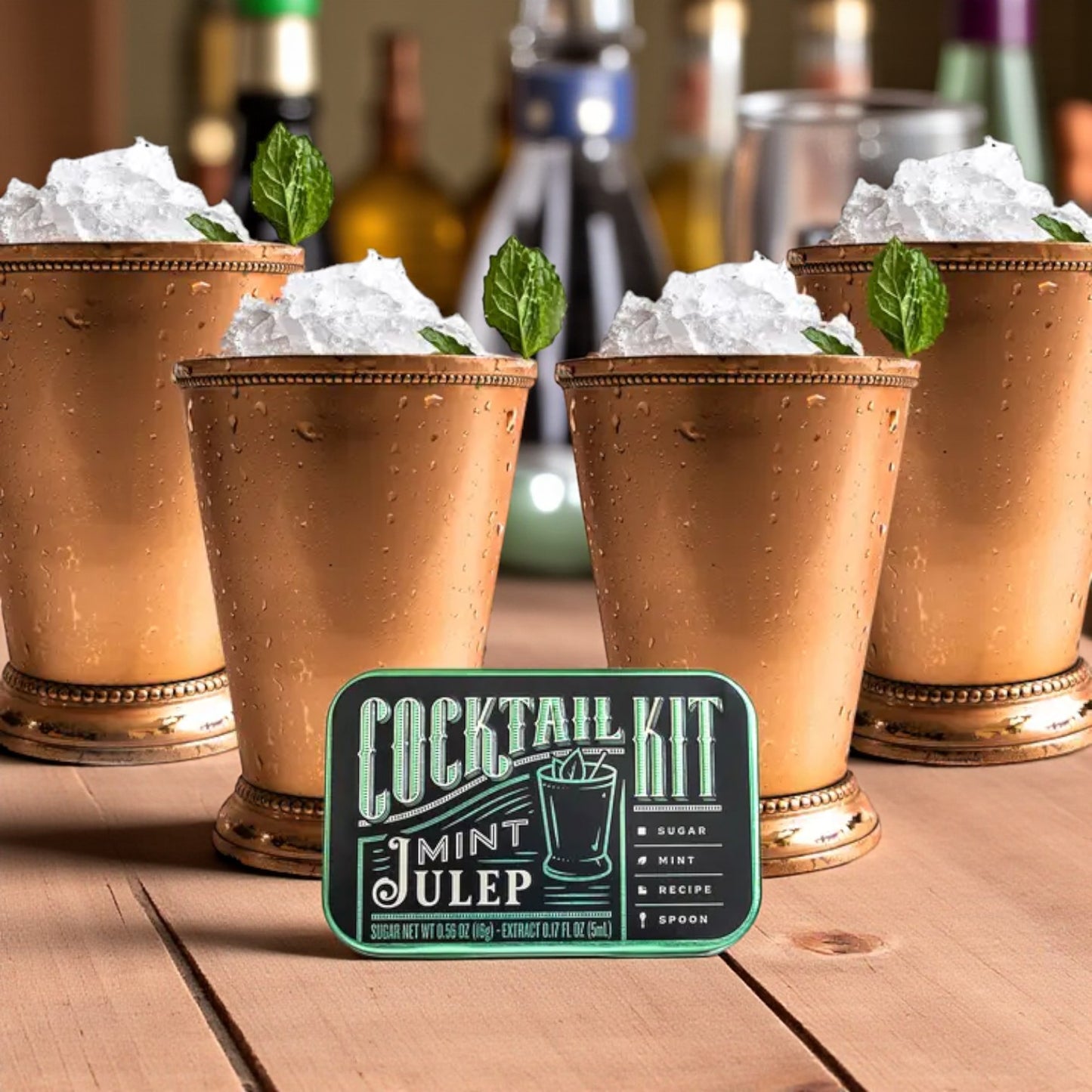 A lifestyle photo of a frosty Mint Julep in a glass next to the open cocktail kit tin.