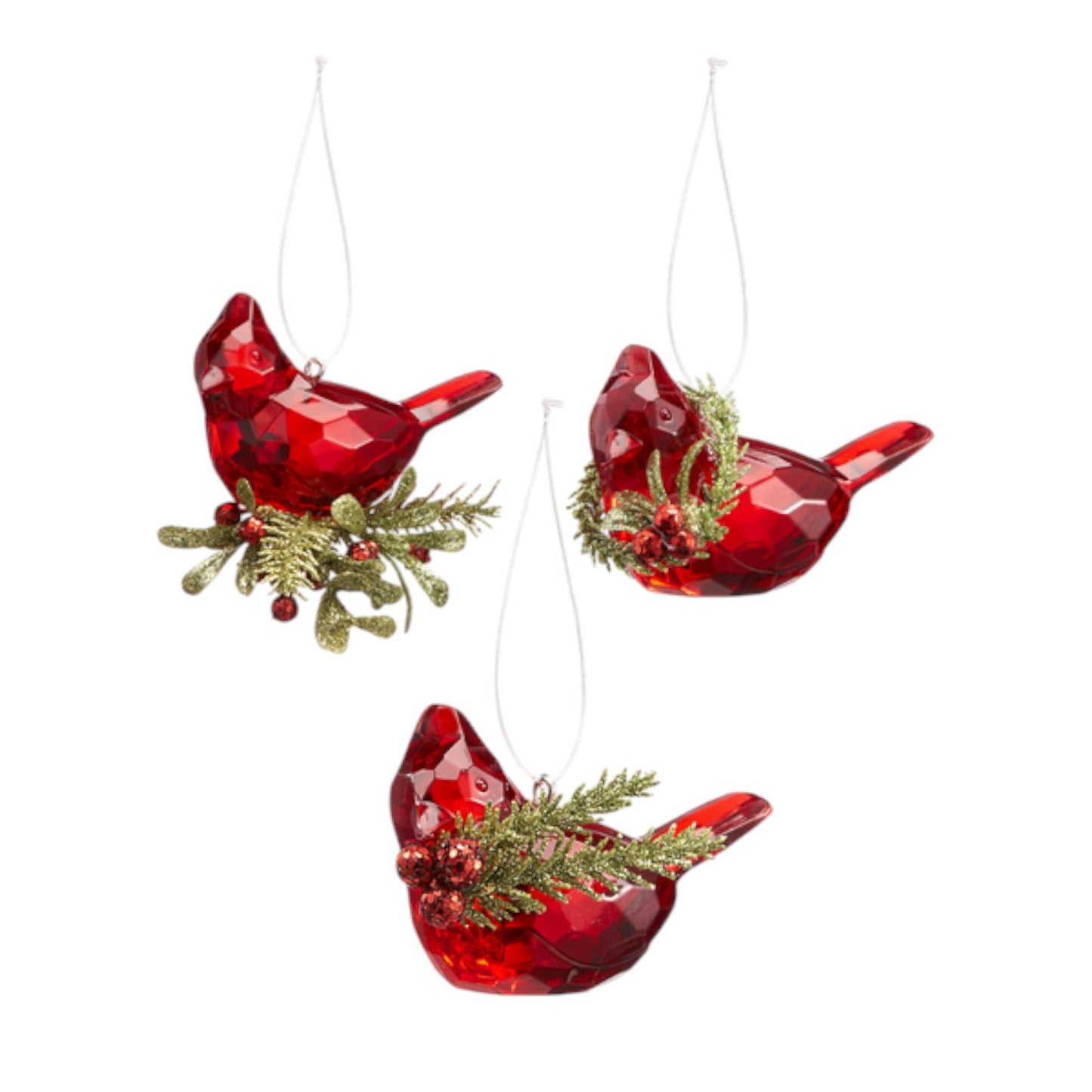 Three red glass cardinal bird ornaments with greenery on a white background