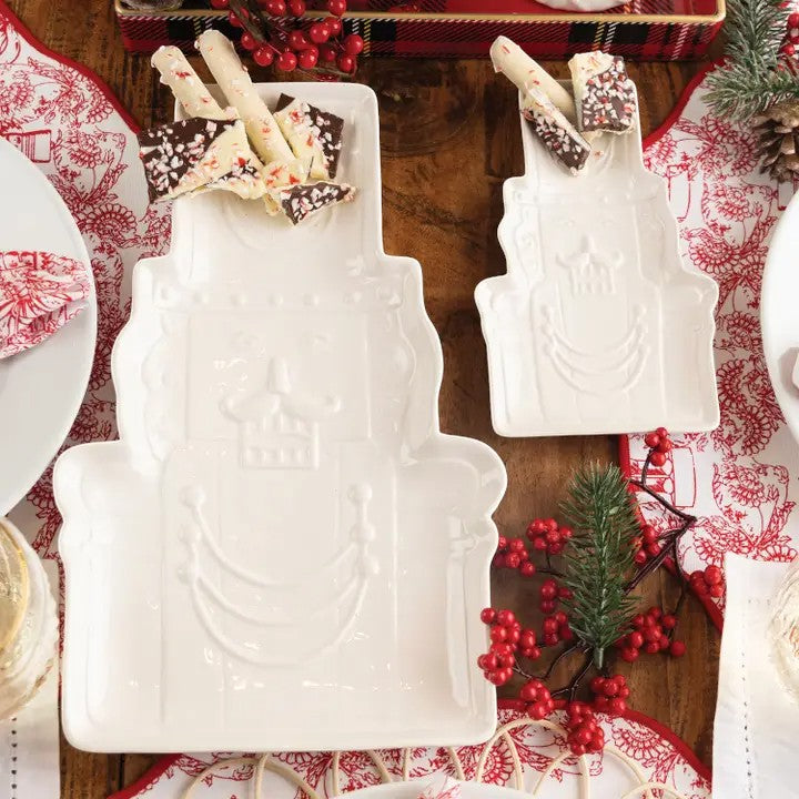 A set of the large and small white ceramic Nutcracker serving dishes on a festive table.