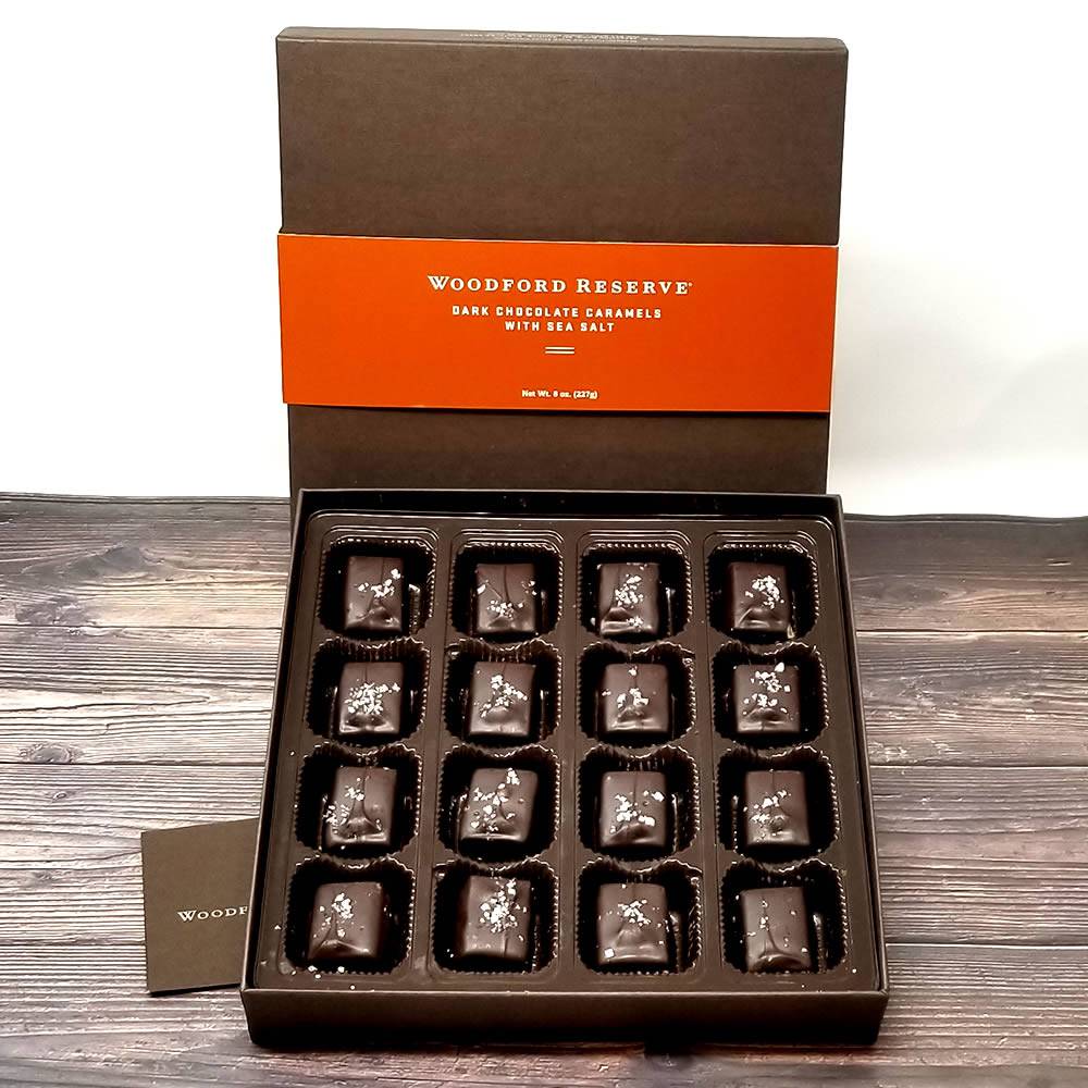 Box of Woodford Reserve dark chocolate caramels with sea salt on a wooden surface