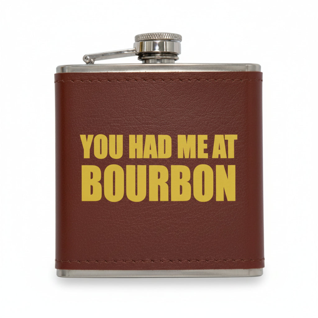 Brown leather flask with 'YOU HAD ME AT BOURBON' text on a white background