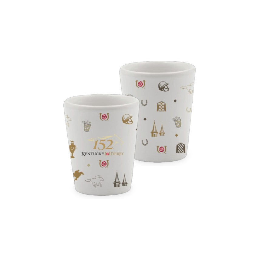 Two white ceramic 1.75 oz shot glasses featuring the 152nd Kentucky Derby text and a wrap-around pattern of gold and red racing icons, including jockey silks, the twin spires, and mint julep cups.