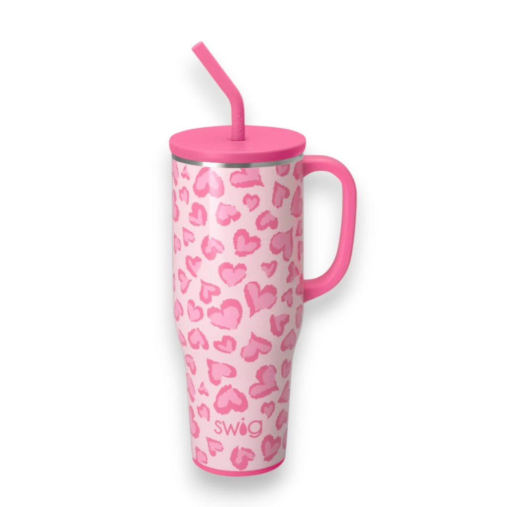Pink tumbler with heart pattern and straw on a white background