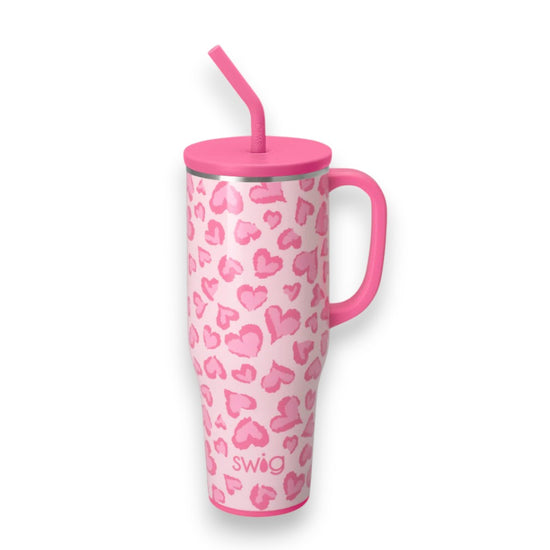 Pink tumbler with heart pattern and straw on a white background