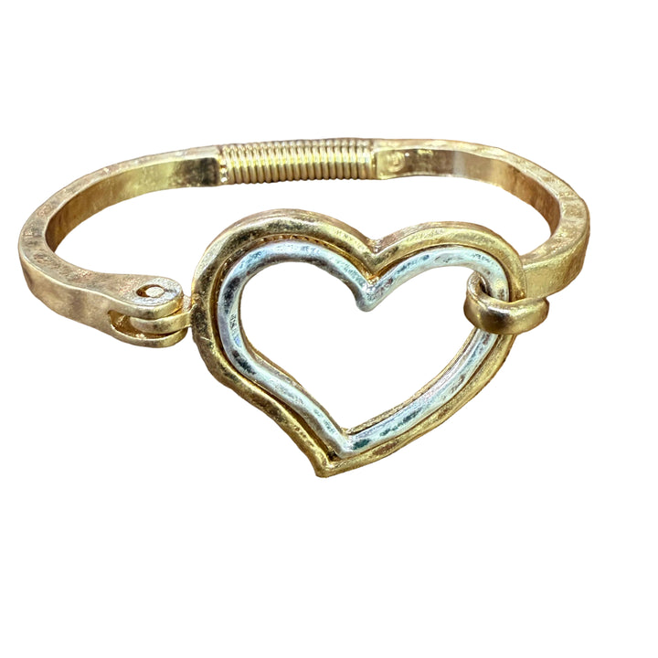 Gold and silver heart-shaped bracelet on a wooden surface
