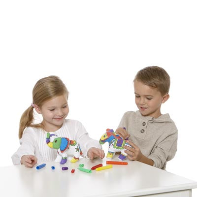 children sitting at a table, coloring plush horse and elephant with colorful markers