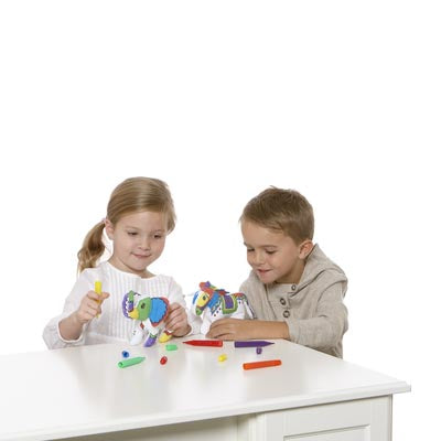 children sitting at a table, coloring plush horse and elephant with colorful markers