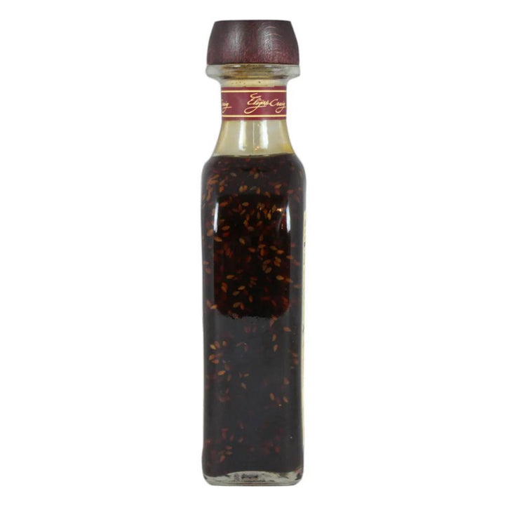 Bottle of dark liquid with a red cap on a white background