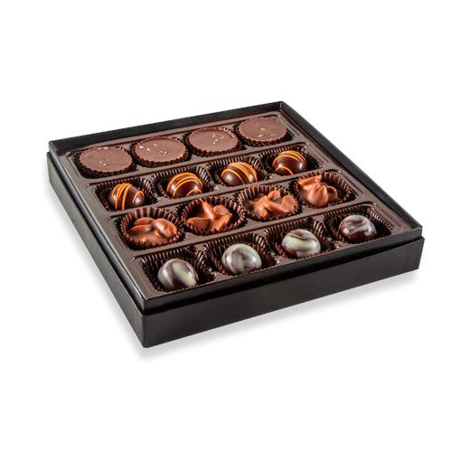 An open box showing 16 handcrafted chocolates, with four distinct varieties arranged in rows.