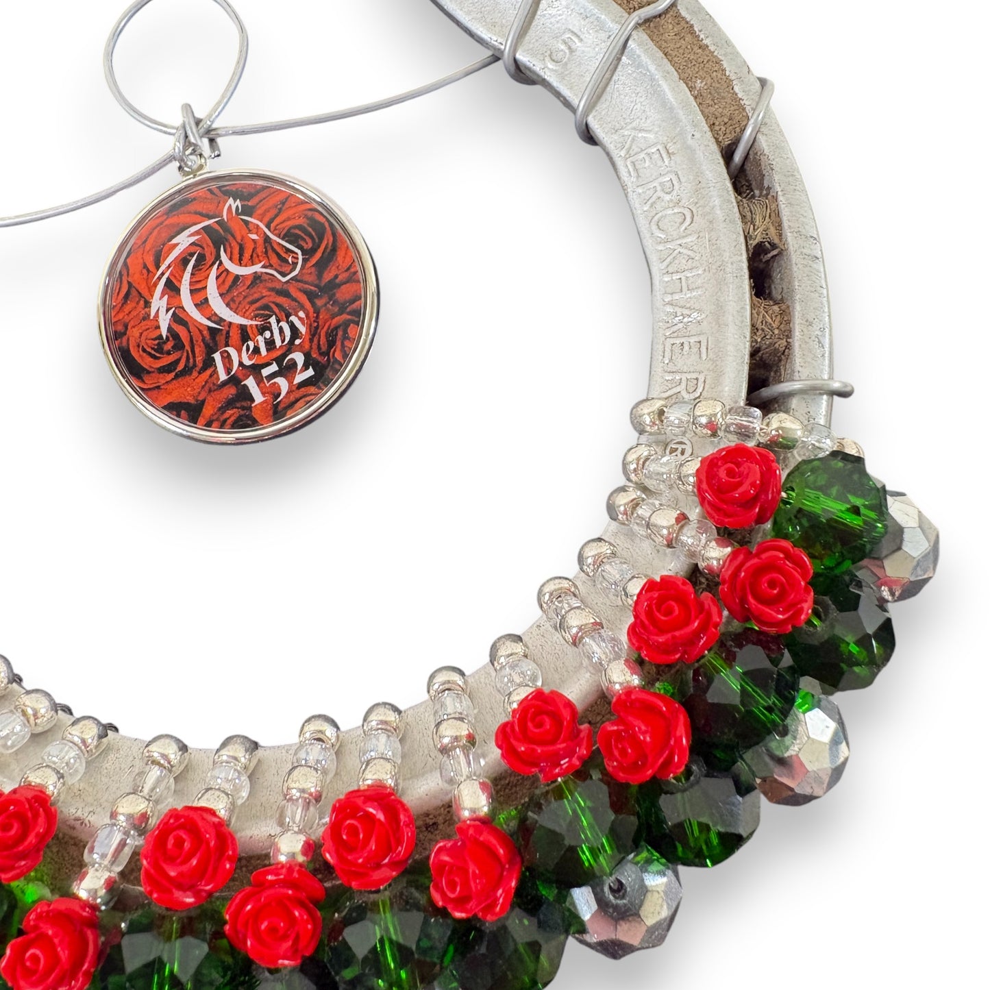 Macro shot showing the authentic track grit on the metal horseshoe contrasted with the shiny beads and 152 charm.