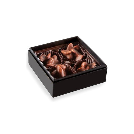 An open box displaying four bourbon smoked salt & pepper peanut clusters.