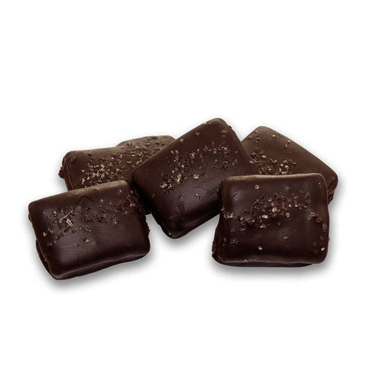 Close-up of the dark chocolate surface sprinkled with coarse bourbon smoked sea salt.