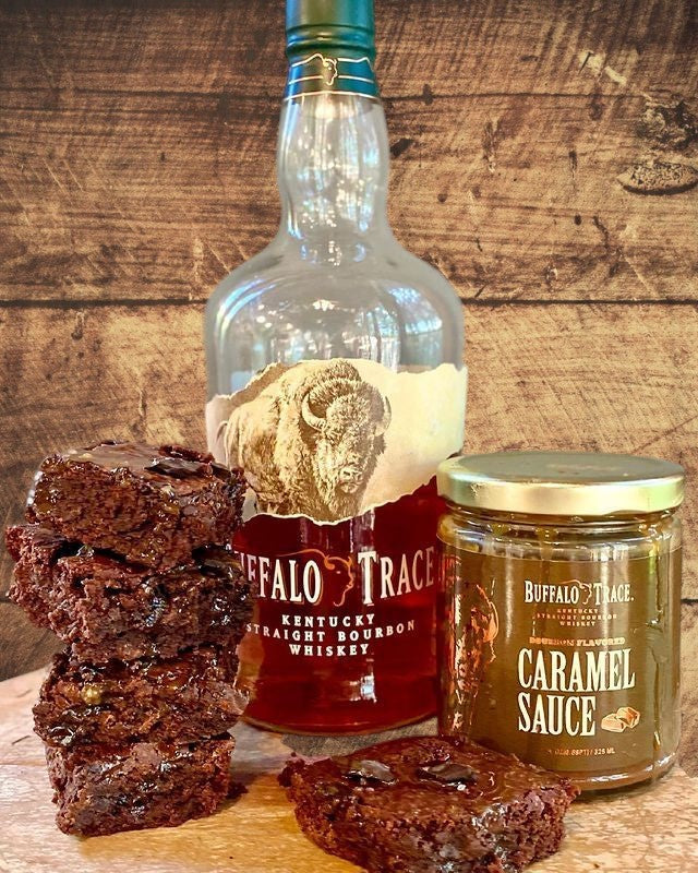 Bottle of Buffalo Trace bourbon with brownies and caramel sauce on a wooden surface