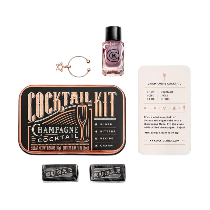 A flatlay showing the contents of the Champagne Cocktail Kit: bitters, sugar cubes, and charm.