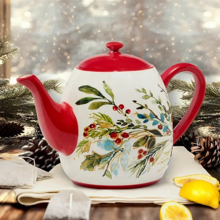 Decorative teapot with floral design and red accents on a table with a festive background.