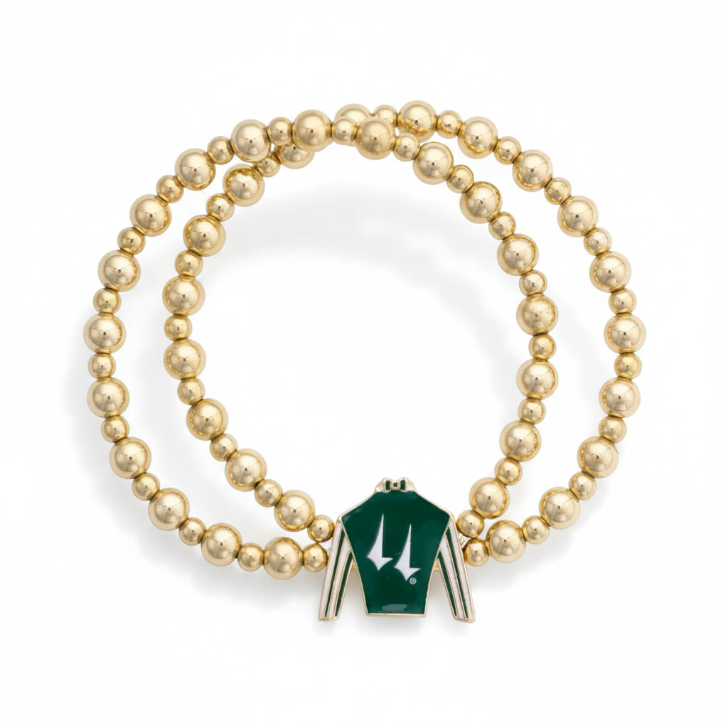  Full view of the Churchill Downs two-row gold bead stretch bracelet, showcasing the green and white jockey silk enamel charm against a white background.