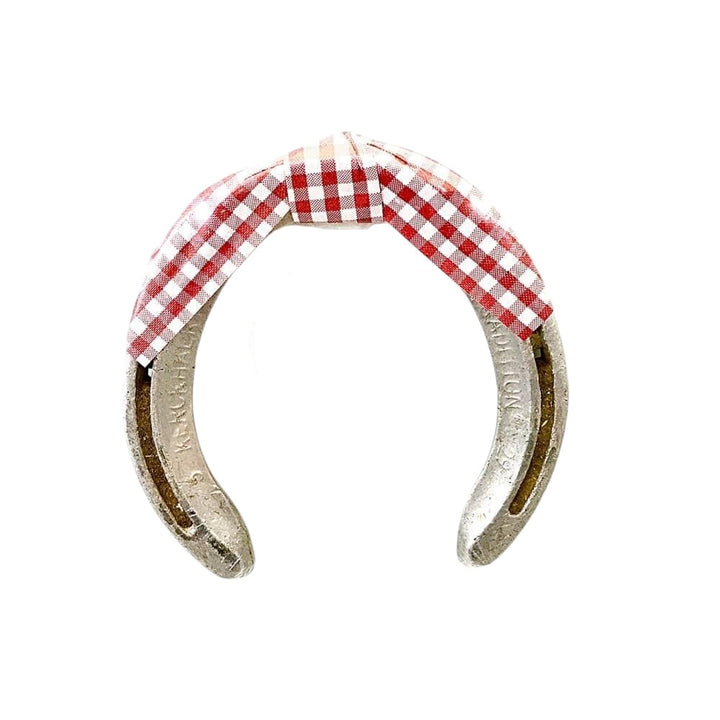 Horseshoe with red and white checkered fabric on a white background