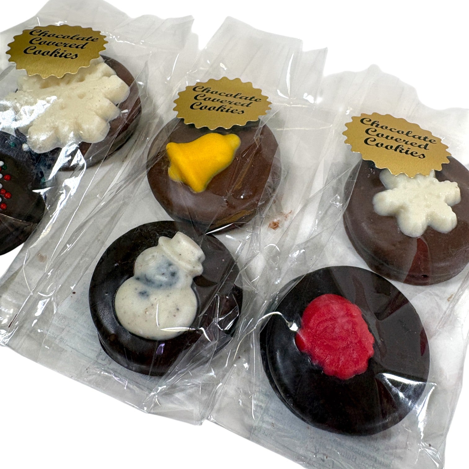 Chocolate-covered cookies with decorative toppings in clear packaging.