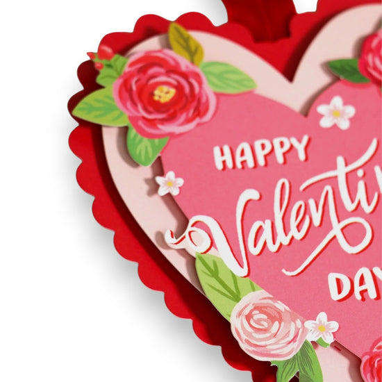Heart-shaped Valentine's Day card with flowers and 'Happy Valentine's Day' text on a white background
