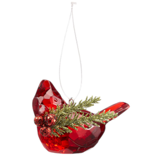 Red glass bird ornament with greenery on a white background