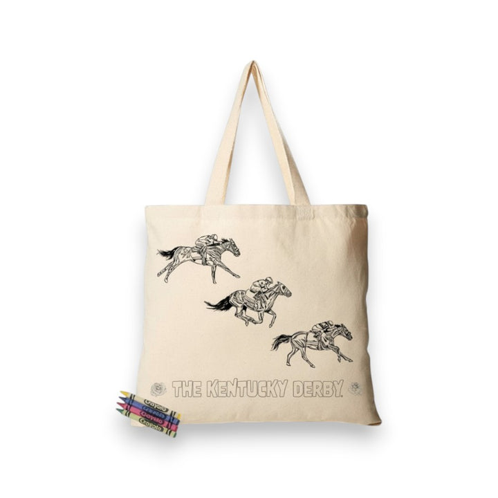 A natural cotton canvas tote bag with black outline drawings of racehorses and "THE KENTUCKY DERBY" text, shown with four Crayola crayons.