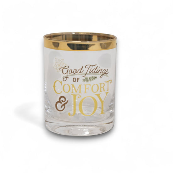 A "Comfort & Joy" glass filled with a holiday beverage and garnished with a cinnamon stick.