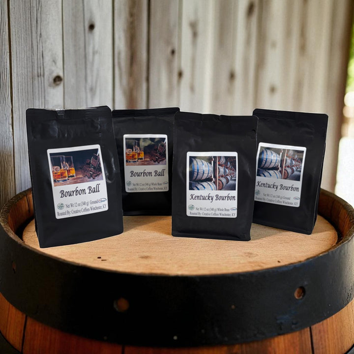 Four black coffee bags with labels on a wooden barrel against a wooden background