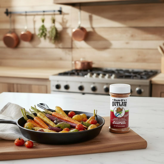 Fried vegetables in a pan on a cutting board with a jar of Dan O's Outlaw Blackened Seasoning in a kitchen setting.