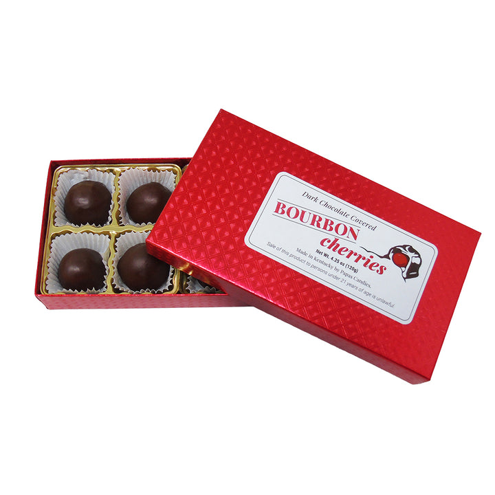 Box of bourbon cherries with a red lid on a white background