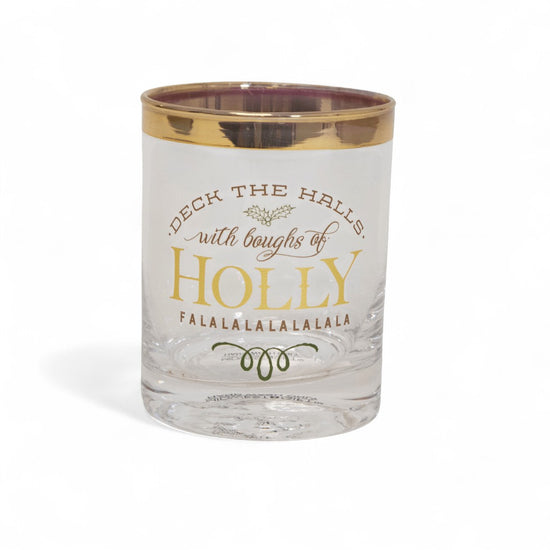 Clear glass tumbler with gold rim and festive text on a white background