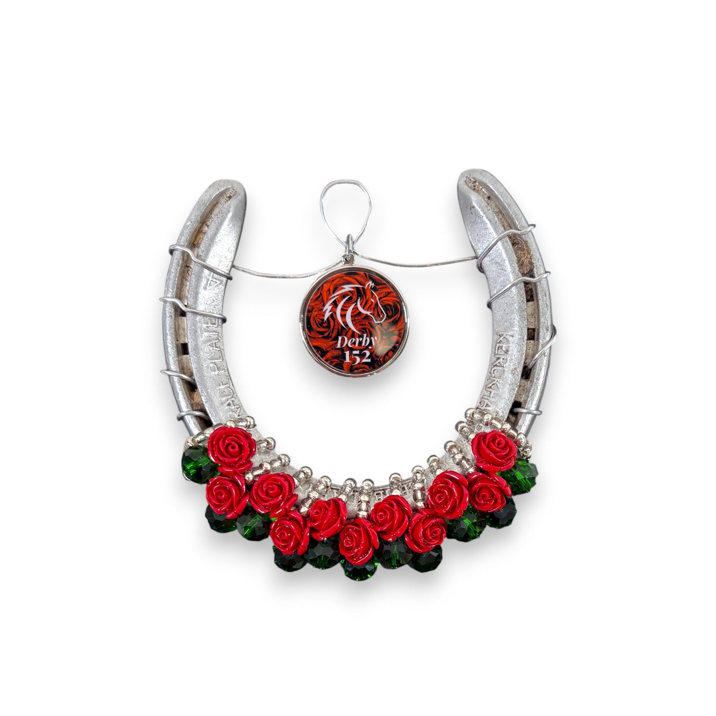 An authentic Churchill Downs horseshoe decorated with a lush garland of red roses and a commemorative "152" charm.