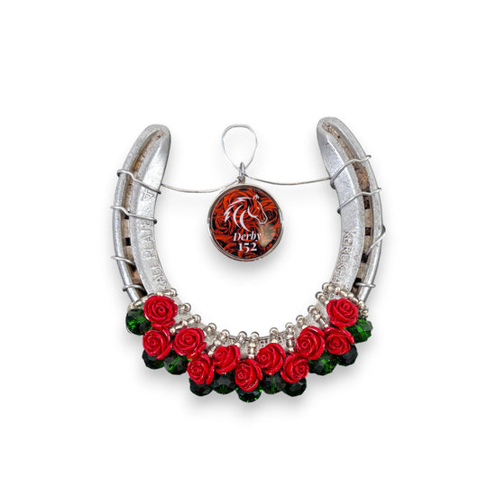 An authentic Churchill Downs horseshoe decorated with a lush garland of red roses and a commemorative "152" charm.
