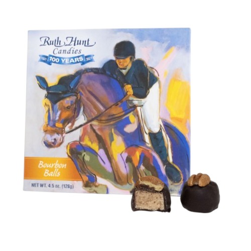 Candy box with horse and rider illustration and two bourbon balls in front