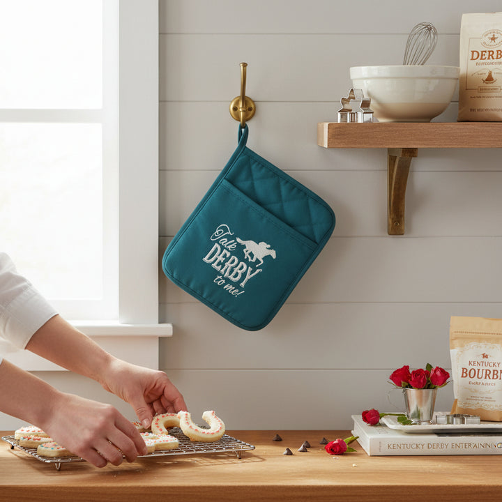 A Derby-themed kitchen scene featuring the teal pot holder hanging on a hook next to baking supplies.