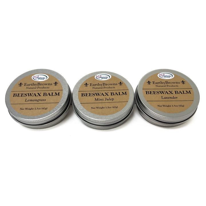 Three tins of Beeswax Balm with different scents on a white background
