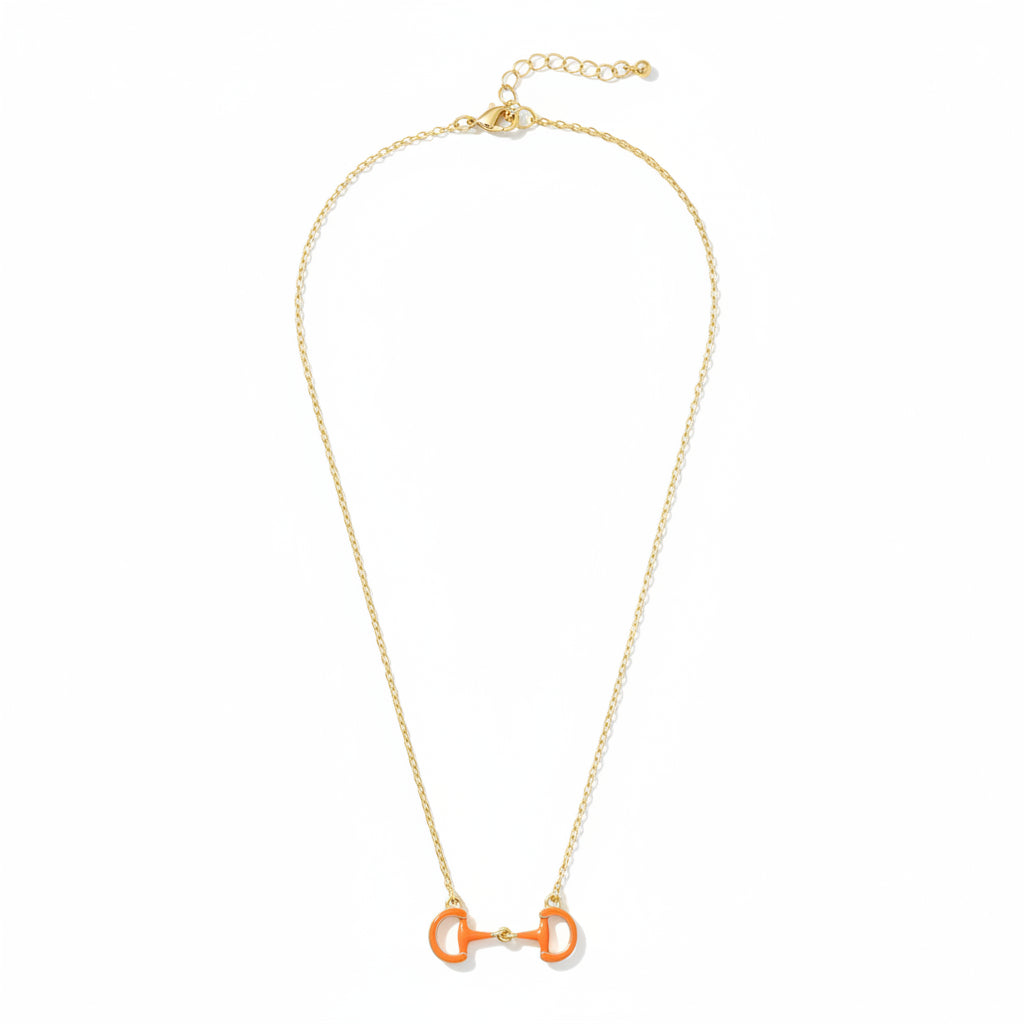 A close-up detail shot of the Orange Eclipse Enamel Horsebit Necklace pendant on its gold-tone chain.