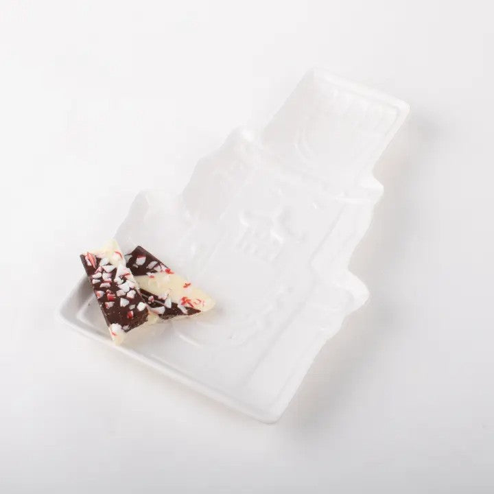 The white Nutcracker dish filled with peppermint bark and holiday cookies.