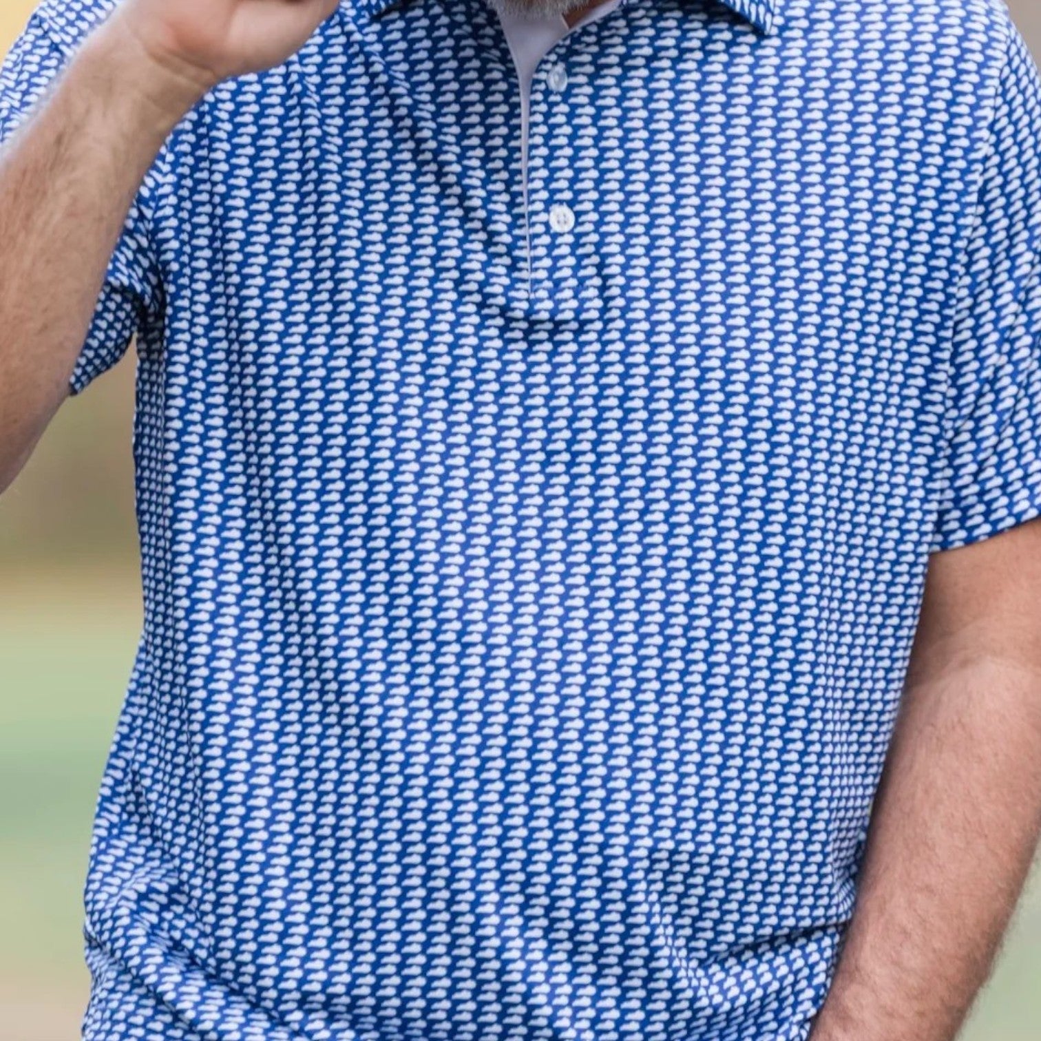 A close-up of the polo shirt showcasing the intricate blue and white micro-pattern and the performance fabric texture.
