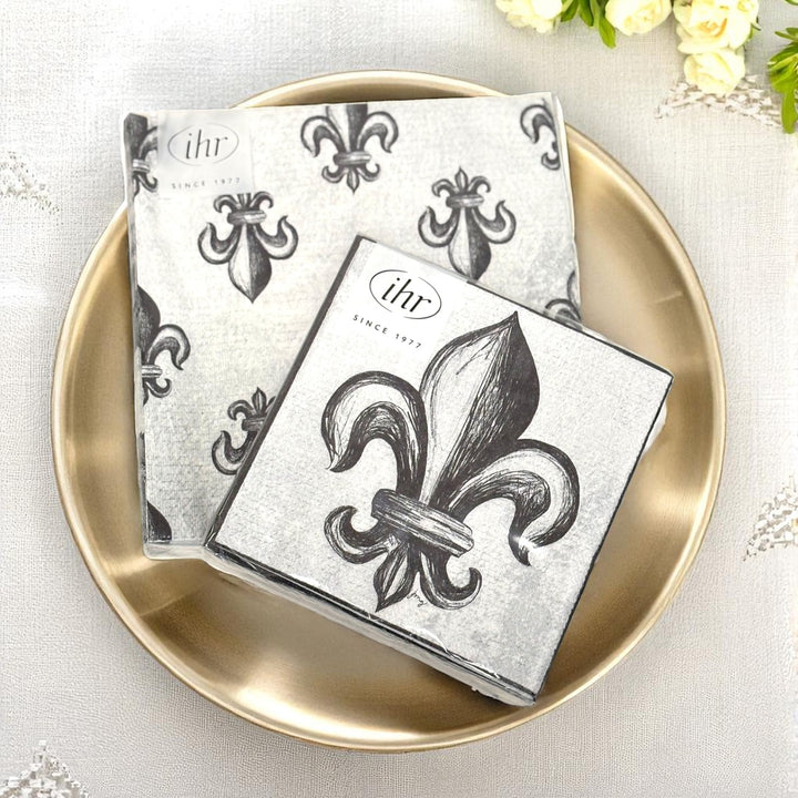 An elegant table setting featuring the Fleur-de-Lis napkins paired with a gold charger and glassware for a party.
