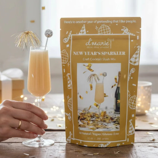 New Year's Sparkler cocktail mix package with a cocktail on a wooden surface.