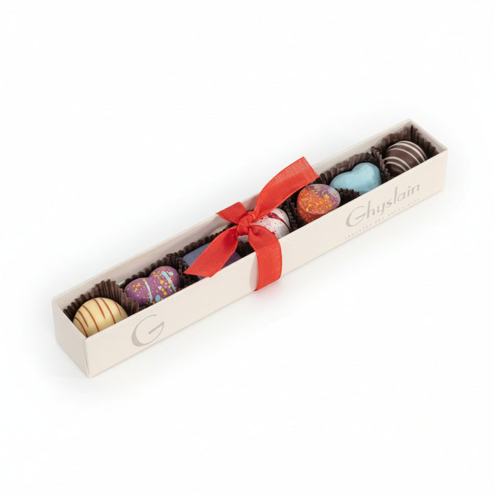 The Ghyslain Valentine Sleeve box featuring a window view of seven colorful, hand-painted chocolates.